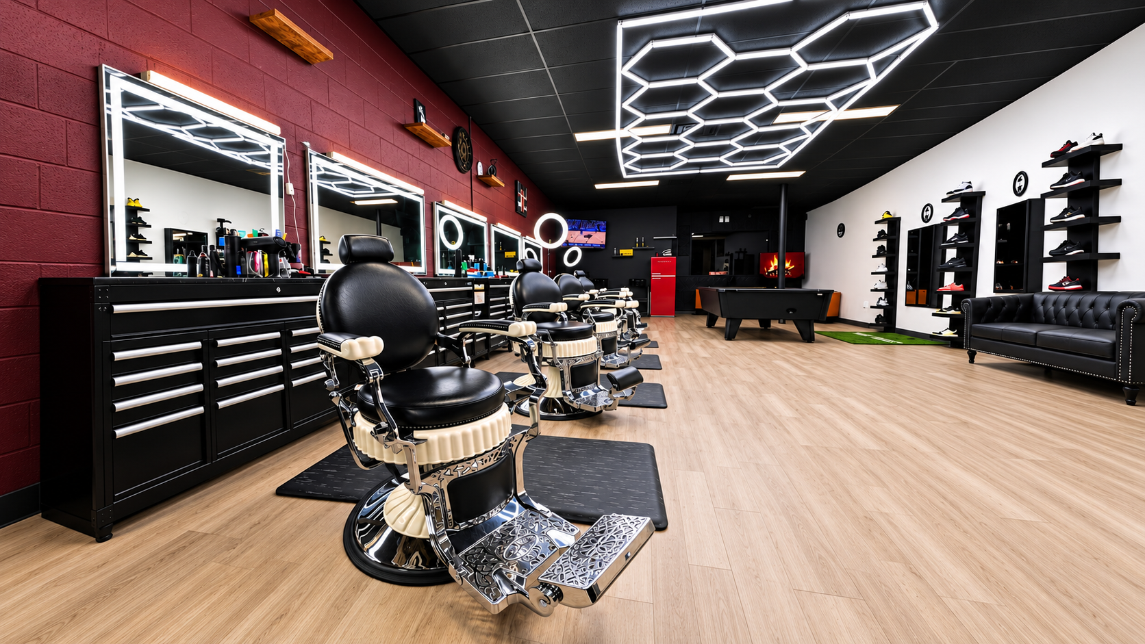 God Level Barbershop interior: chrome barber chairs in front of illuminated mirrors, burgundy brick wall and the pool table at the back